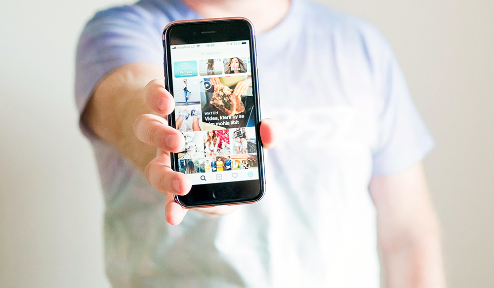 man holding phone instagram screen